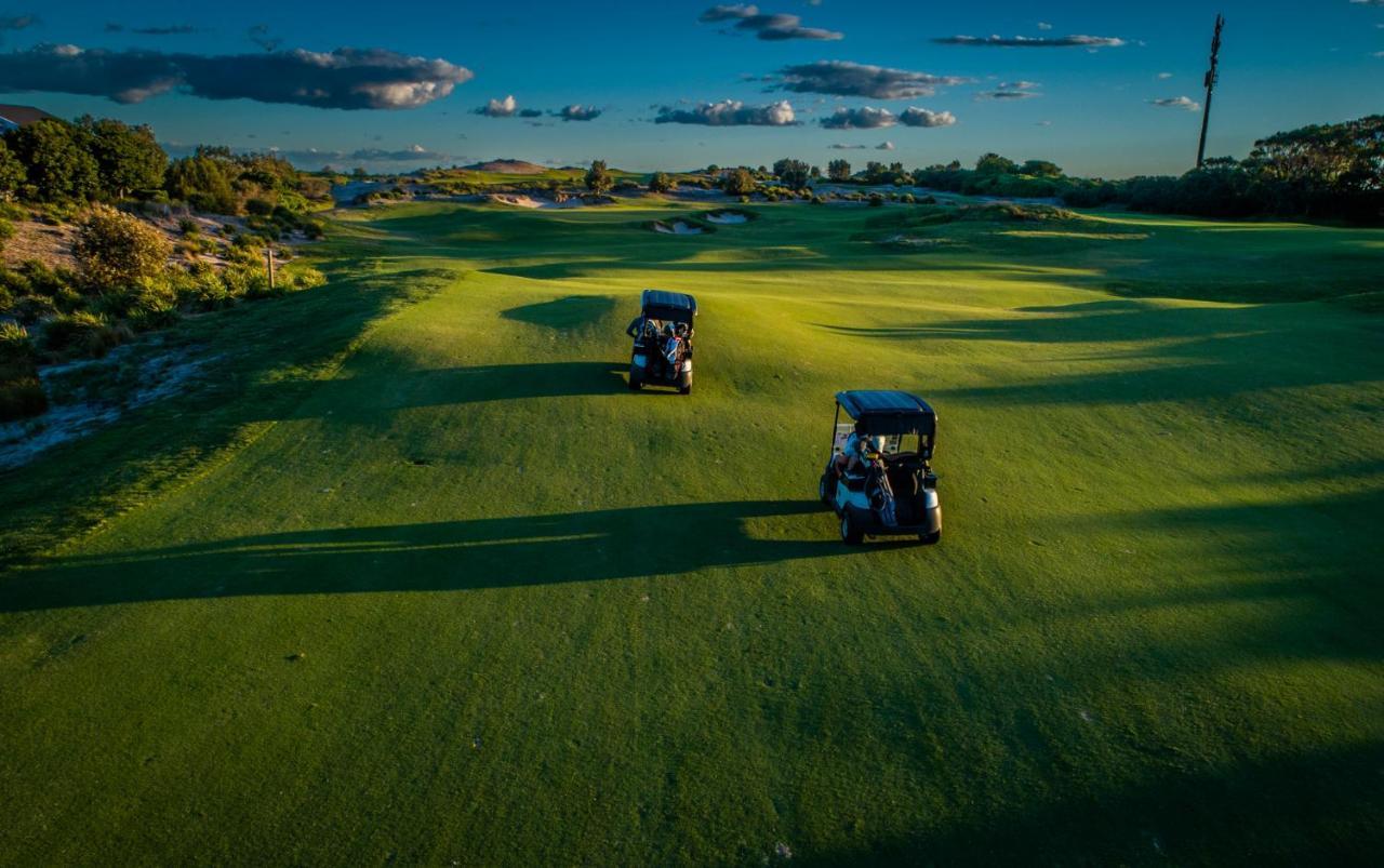 Pullman Magenta Shores Resort Entrance Eksteriør bilde Golf carts on the green